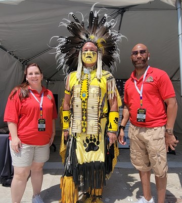 Participating_exhibitors,_Native_American_Percy_Warcloud_Edwards_stands_between_members_of_the_Defense_Commissary_Agency.